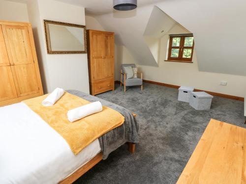a bedroom with a bed and a chair at Ty Melyn in Boncath