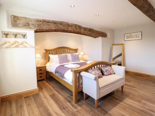 a bedroom with a bed and a chair at Plas Iolyn in Betws-y-coed