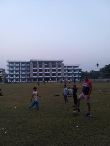 eine Gruppe von Menschen, die auf einem Feld Fußball spielen in der Unterkunft Amzad Da in Khulna