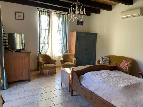 1 dormitorio con cama, sillas y lámpara de araña en La Manufacture Royale de Bains, en Bains-les-Bains