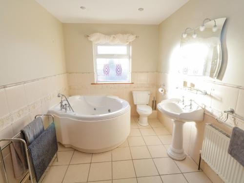 a bathroom with a tub and a toilet and a sink at Home Farm Retreat in Williamstown