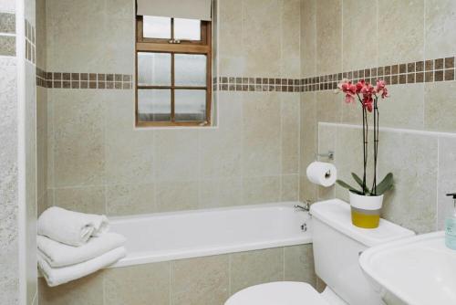 La salle de bains est pourvue d'une baignoire, de toilettes et d'un lavabo. dans l'établissement Heather Cottages - Godwit, à Bamburgh