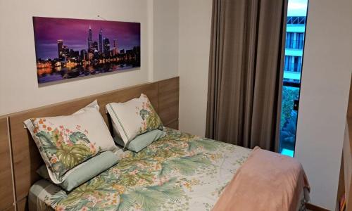 1 dormitorio con 1 cama con 2 almohadas y ventana en Apart Hotel - Park Sul, en Brasilia