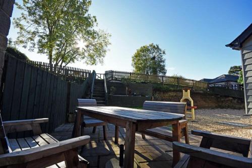 a wooden picnic table and benches in a backyard at Millstone in Lucker