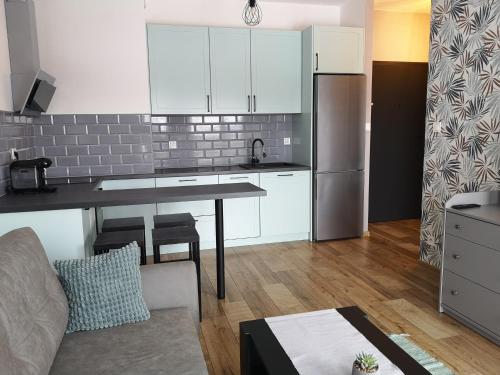 uma cozinha com armários brancos e uma mesa num quarto em Apartament dla Ciebie em Lańcut