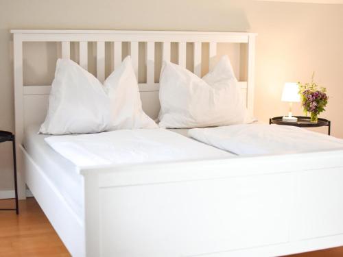 ein weißes Bett mit weißen Kissen darauf in der Unterkunft Ferienwohnung am Sattelhof #2 in Türnitz