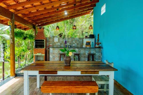 an outdoor kitchen with a wooden table in a room at Suítes da Barra in Ubatuba