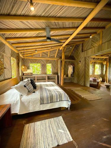 a bedroom with a bed in a room with wooden ceilings at Cabaña junto al mar in Zihuatanejo