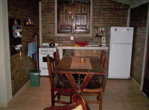 cocina con mesa y nevera blanca en Casa Câmeron del Mar en San Rafael