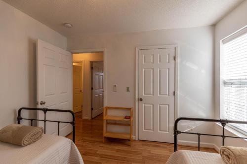 a white bedroom with two beds and a window at Seven Devils Sunrise in Seven Devils