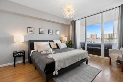 a bedroom with a large bed and a large window at Waterfront luxury new apartment in Miami Beach