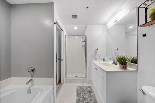 a white bathroom with a tub and a sink and a shower at Waterfront Luxury 2-Bedroom Condo Sunny Isles Beach in Miami Beach