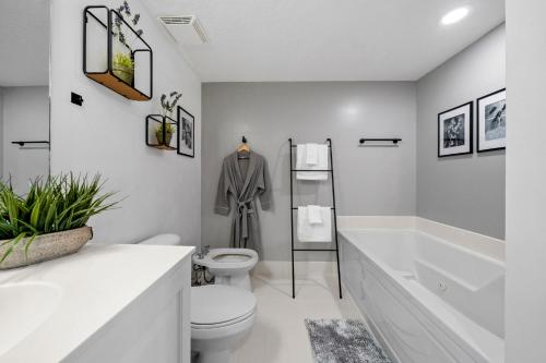 a white bathroom with a toilet and a bath tub at Waterfront luxury new apartment in Miami Beach