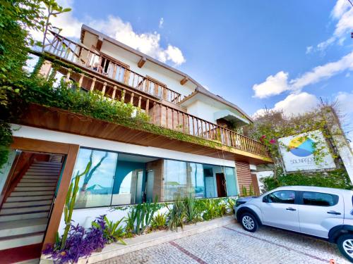 a white car parked in front of a building at Sol Nascente Hotel Pousada Beira Mar in Natal