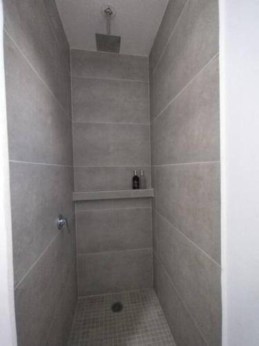 a bathroom with a shower with a tiled floor at Amplio departamento CASA MANGO in Ciudad Fernández