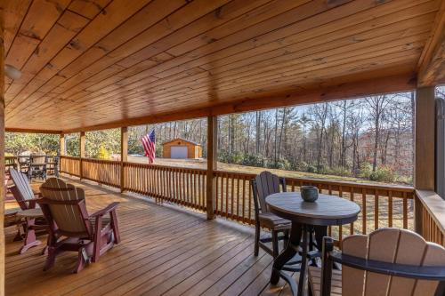 a wooden deck with tables and chairs on it at Leafy Way Lodge in Linville Falls