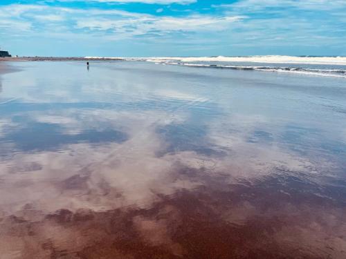a person standing in the water on the beach at The Beach Break Hotel El Zonte in El Zonte