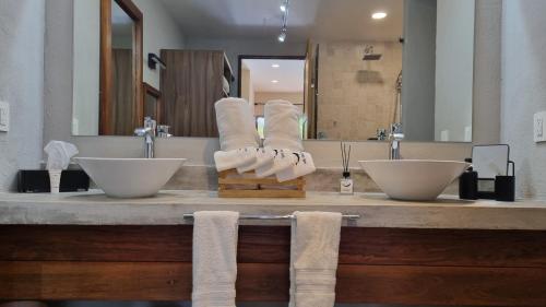 a bathroom with two sinks and towels on a counter at Casa de la Ballena in Sayulita