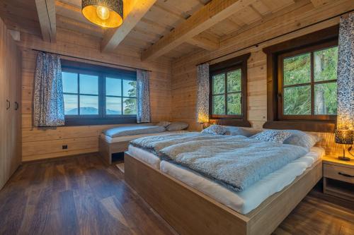 a bedroom with two beds in a room with windows at Drevenica Lesanka in Demanovska Dolina