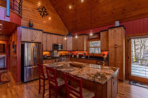 a kitchen with wooden cabinets and a large island with chairs at A River Mist Walk in Sugar Grove