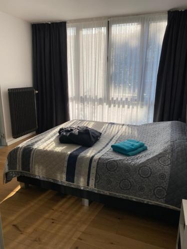 Un dormitorio con una cama con toallas azules. en Appartement met groot terras en Mortsel