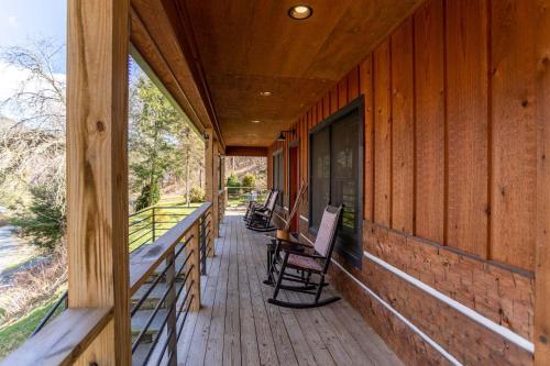 a porch of a wooden house with chairs on it at A River Mist Walk in Sugar Grove