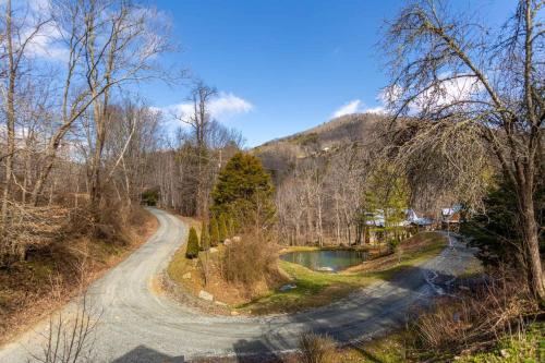 a dirt road next to a lake and a mountain at A River Mist Walk in Sugar Grove