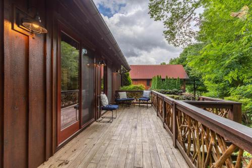 a wooden deck with chairs on a house at River Sound Cabin at Eagles Nest in Banner Elk