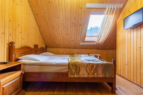 a bedroom with a bed in a wooden room at Villa Nikoletta SPA in Bukovel