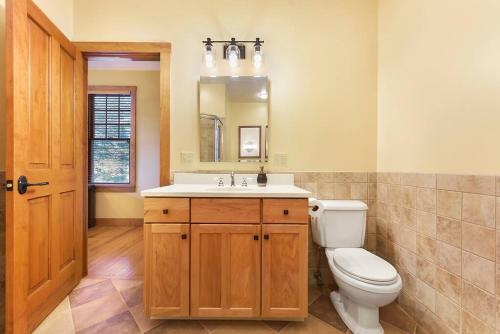 a bathroom with a toilet and a sink and a mirror at Wisp'd Away in Swanton