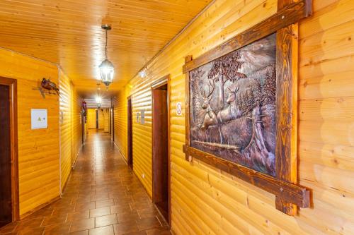 a hallway with a painting on a wooden wall at Villa Nikoletta SPA in Bukovel