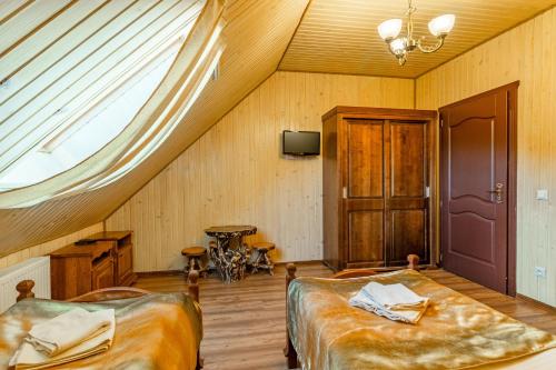 a attic bedroom with two beds and a window at Villa Nikoletta SPA in Bukovel
