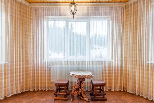 a room with a table and two chairs and a window at Villa Nikoletta SPA in Bukovel