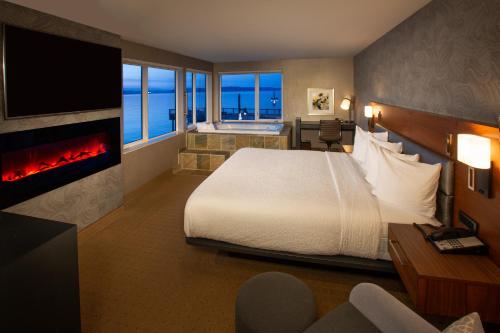 塔科馬的住宿－Silver Cloud Hotel Tacoma Waterfront，酒店客房配有一张床和一个壁炉。