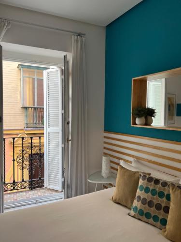 ein Schlafzimmer mit einem Bett und einem Balkon in der Unterkunft Iberflat Fabiola in Sevilla