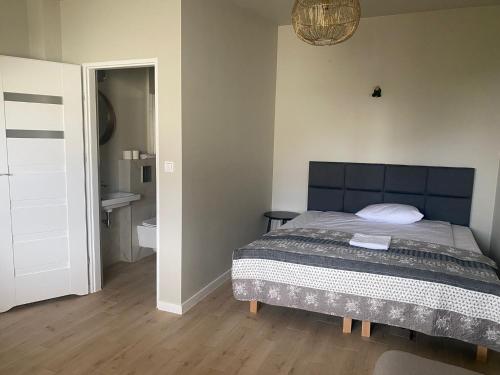 1 dormitorio con 1 cama y baño en Pokoje Nadrzeczna, en Augustów