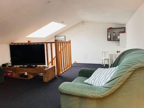 un salon avec un canapé et une télévision à écran plat dans l'établissement Superbe maison plein centre, à Merville