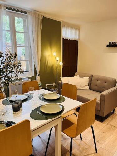 un salon avec une table avec des chaises et un canapé dans l'établissement Superbe maison plein centre, à Merville
