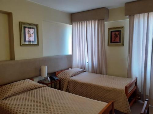 a hotel room with two beds and a window at Hotel Melodia in Lima