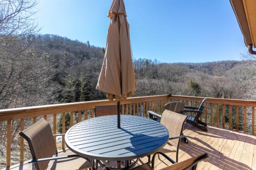 a table with an umbrella and chairs on a deck at Pine Creek Cabin in Blowing Rock