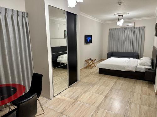 Schlafzimmer mit einem Bett, einem Spiegel und einem Tisch in der Unterkunft Abu Alsoud Hotel in Amman