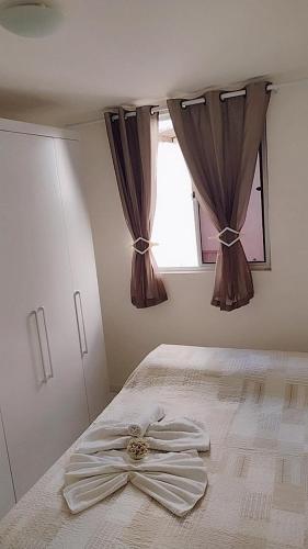 a bedroom with a bed with a bow on it at Apartamento aconchegante Parnamirim Natal in Parnamirim
