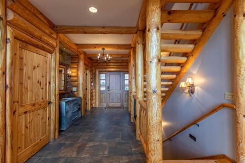 a hallway in a log cabin with wooden walls and stairs at Good Day Sunshine in Lenoir