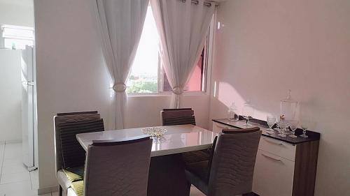 a kitchen with a table and chairs and a window at Apartamento aconchegante Parnamirim Natal in Parnamirim