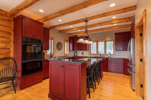 a kitchen with red cabinets and an island with bar stools at Good Day Sunshine in Lenoir