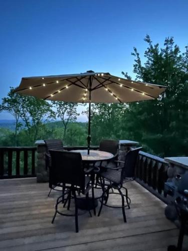 a table and chairs on a deck with an umbrella at Good Day Sunshine in Lenoir