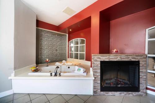 a large bathroom with a fireplace and a tub at Post Road Inn Motel in Avenel