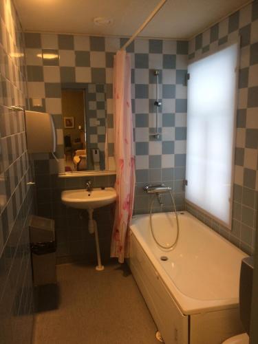 a bathroom with a tub and a sink and a bath tub at Koljonvirran Kartano in Iisalmi