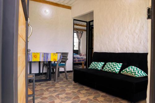un soggiorno con divano nero e tavolo di Finca Las Aguas a Calima