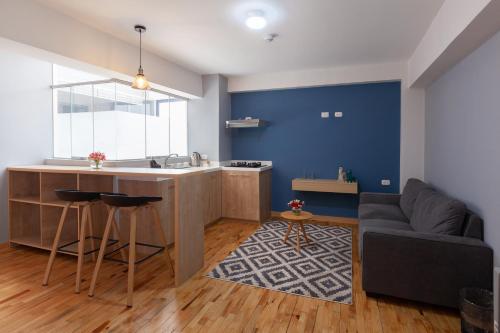 a kitchen and living room with a blue wall at Muru Homely Hotel Cusco in Cusco